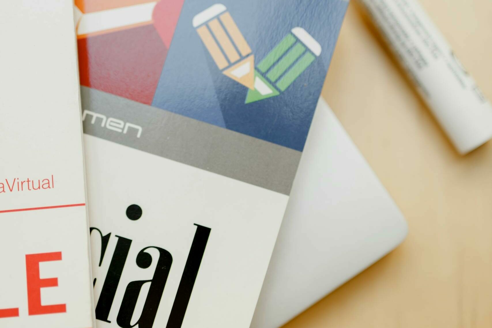 Close-up shot of Spanish language books and a marker on a wooden surface.